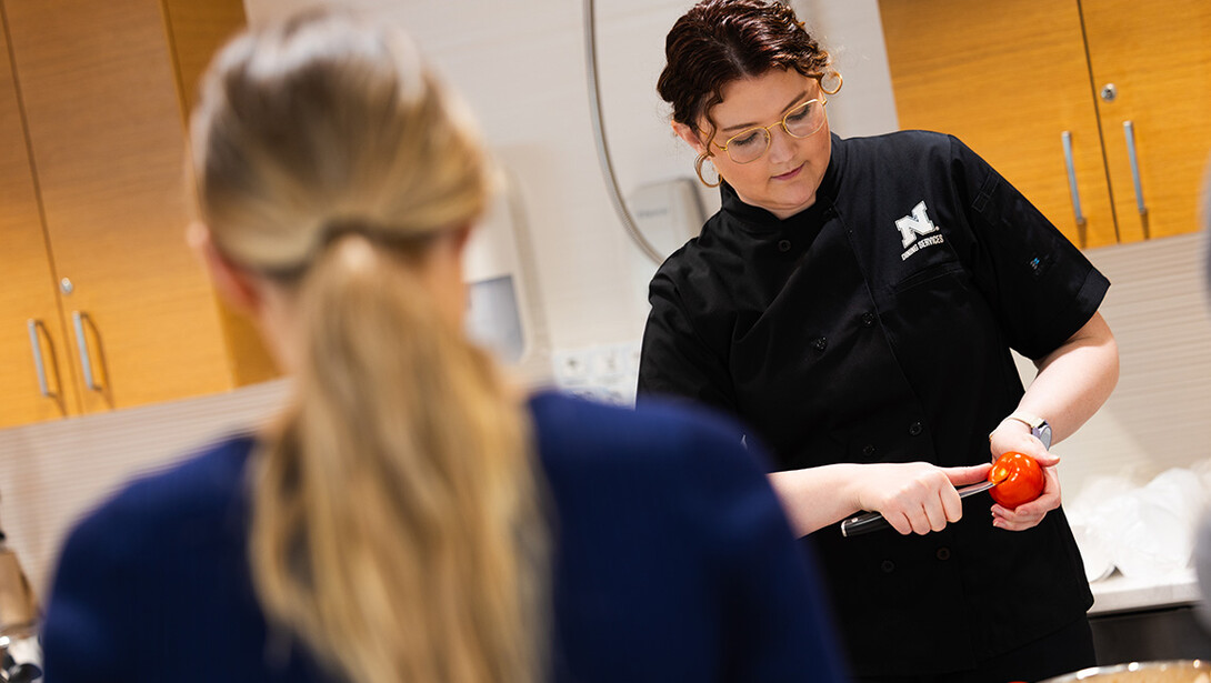 Ellyn McCarter, dietician and nutrition manager with Dining Services, shows students how to core a tomato during a cooking demonstration at the University Health Center.